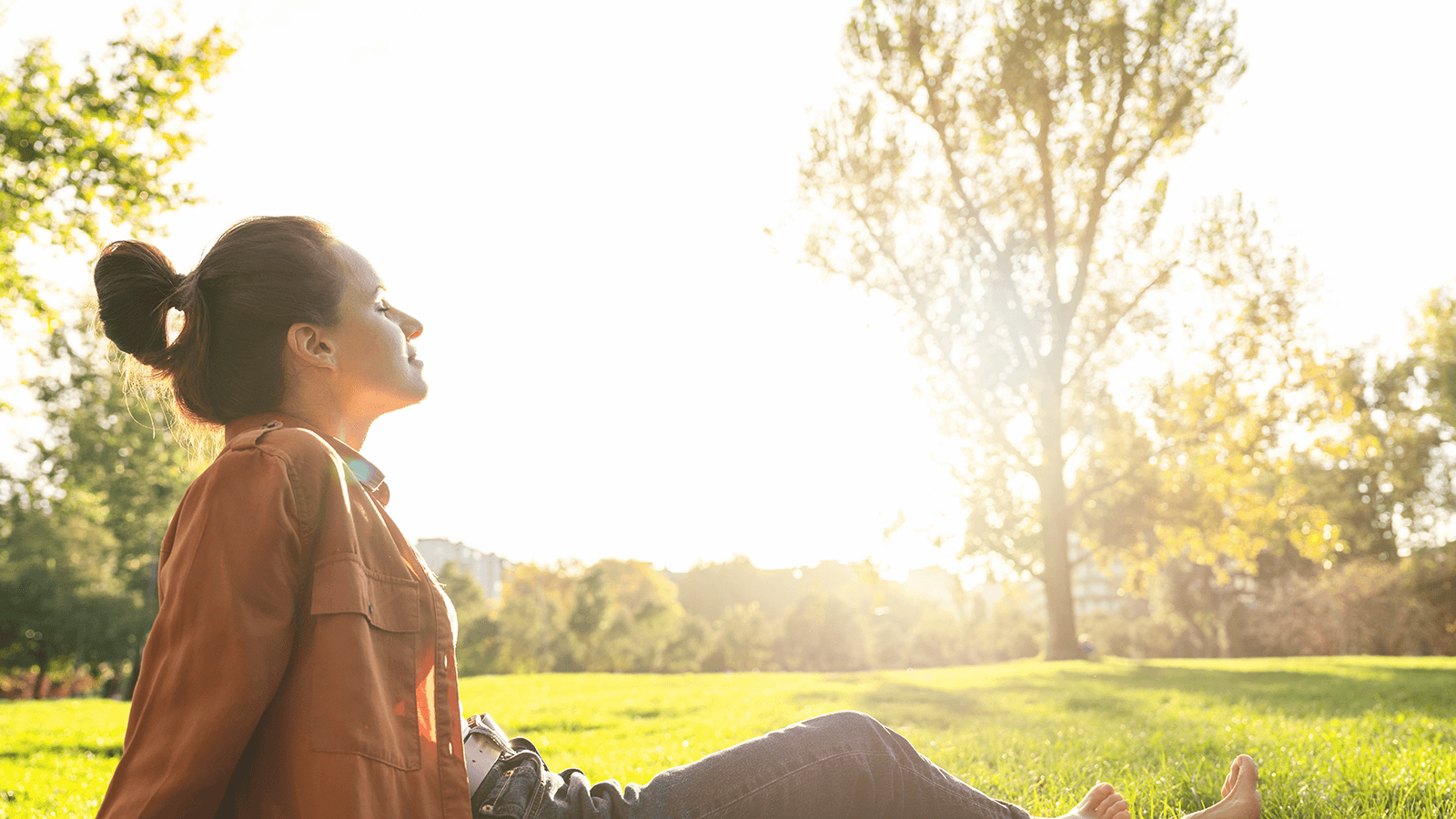 Entspannung durch Ergotherapie: Frau genießt Achtsamkeitsmoment im Grünen – mentale Gesundheit und Selbstfürsorge im Alltag stärken