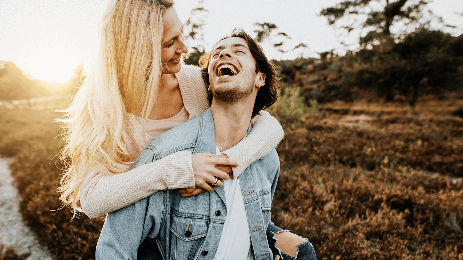 Lebensfreude trotz Herausforderungen – glückliches Paar genießt Naturmoment bei Sonnenuntergang, moderne Ergotherapie begleitet individuell.