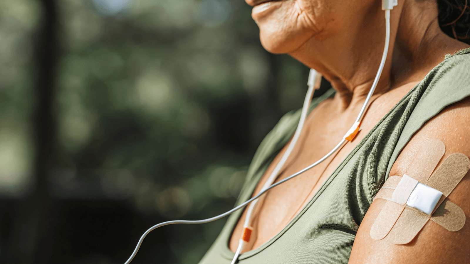 Biofeedback in der Ergotherapie: Seniorin mit Klebeelektroden und Kopfhörern bei moderner Schmerzbehandlung im Alltag